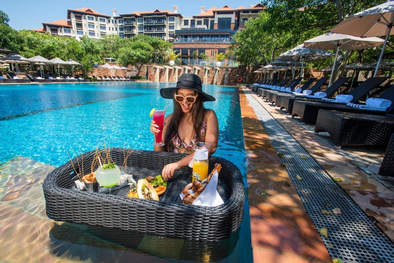 Hotel The Capital Zimbali à Ballito Extérieur photo A woman at a poolside lounge